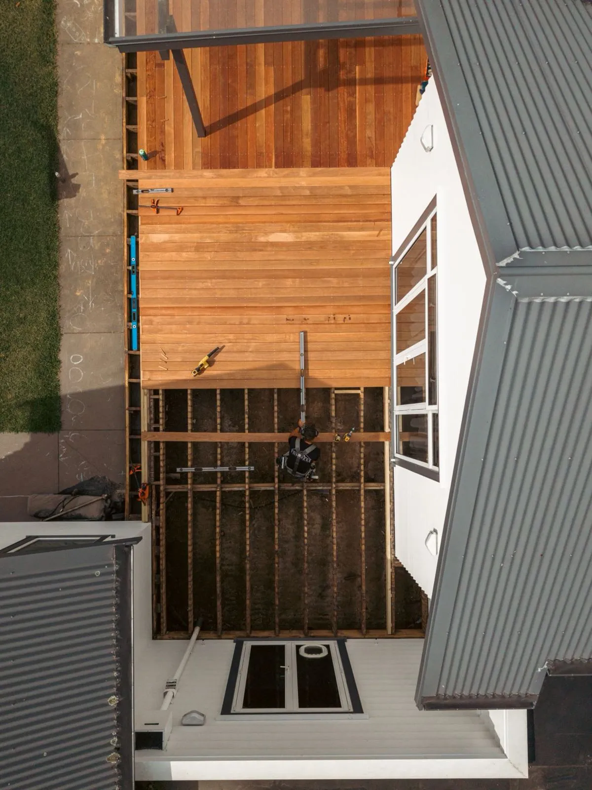 Drone shot of a Fortress Construction builder laying a hardwood deck in Tamahere