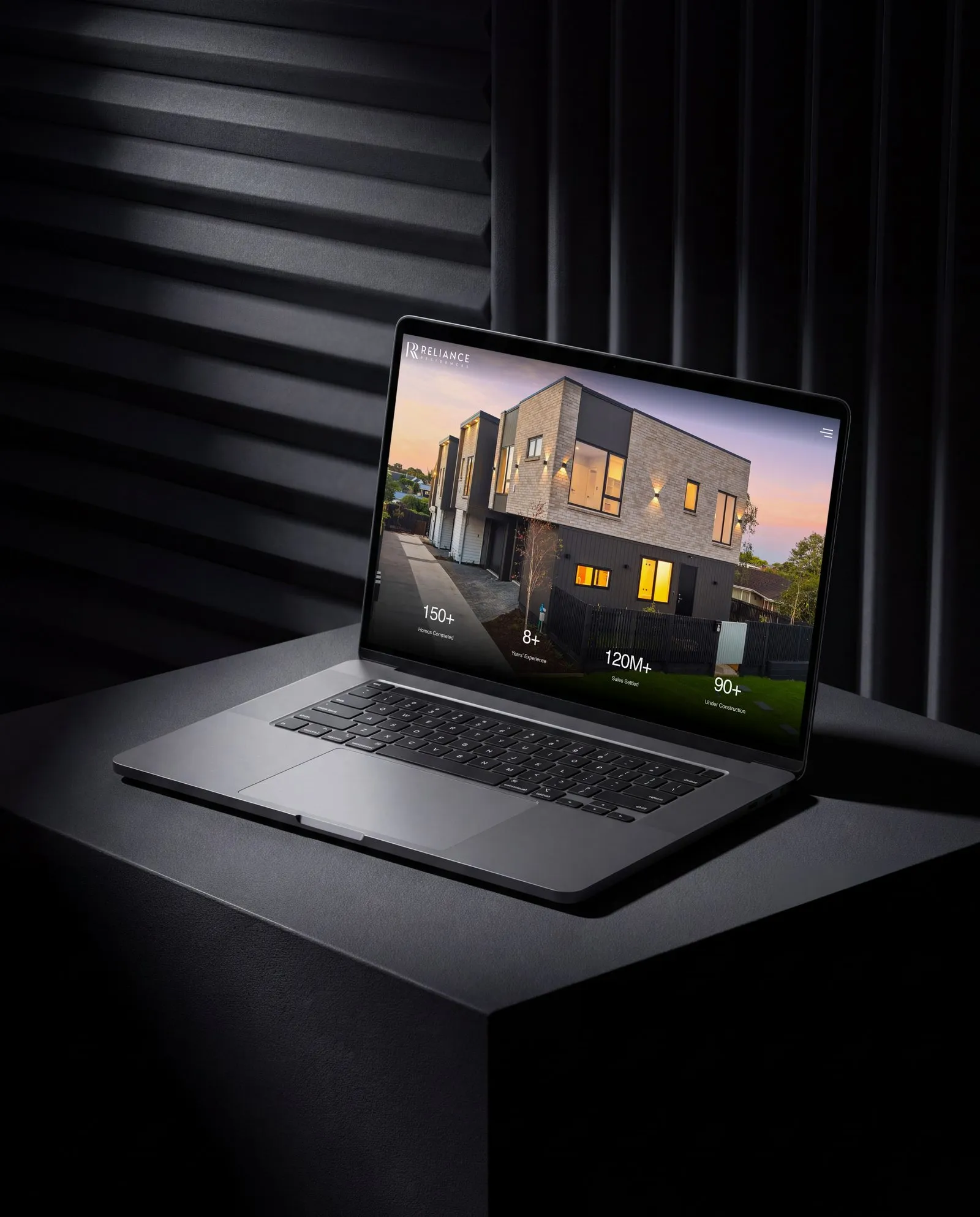 Reliance Residences homepage shown on a laptop